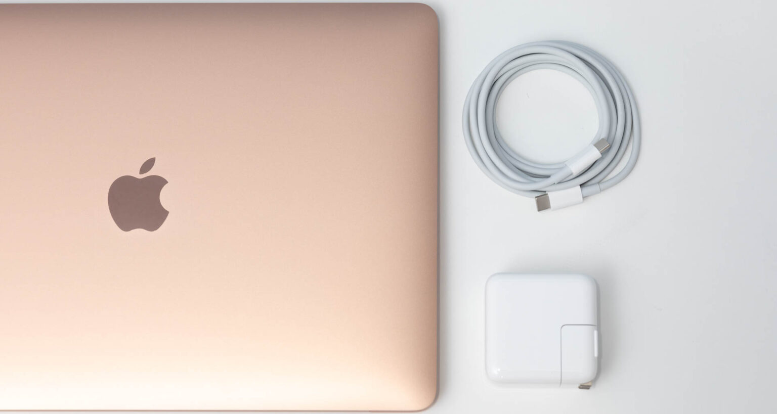 Apple MacBook Air M1 with USB-C power adapter and cable.